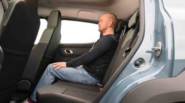 Dacia Spring - rear seats with Auto Express Chief reviewer, Alex Ingram